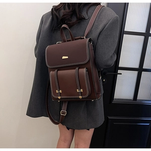 Rear view of a model wearing the vintage dark brown PU leather backpack with contrast stitching