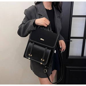 Detail of minimalist black PU leather backpack featuring contrast white stitching and gold hardware