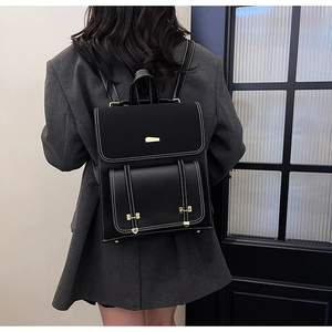 Close-up of a retro PU leather backpack with contrast stitching and golden buckles