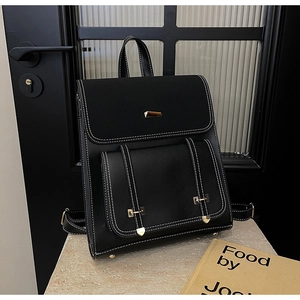 Detail of black PU leather backpack featuring white contrast stitching and gold hardware