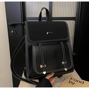 Detail of vintage black PU leather backpack featuring contrast stitching and gold metal buckle