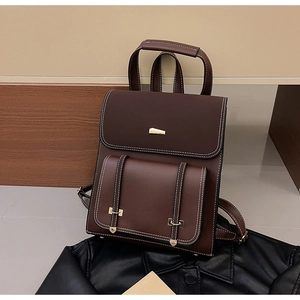 Detail view of dark brown vintage PU leather backpack with contrast stitching and gold hardware