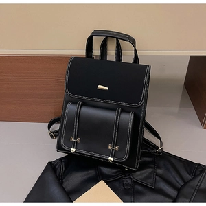 Detail view of black PU leather backpack with contrast stitching and gold metal buckles