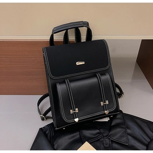 Detail of black vintage PU leather backpack with white contrast stitching and gold buckle