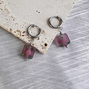 Detail of square purple frosted glass pendant earrings with pink 3D rose and silver hoop