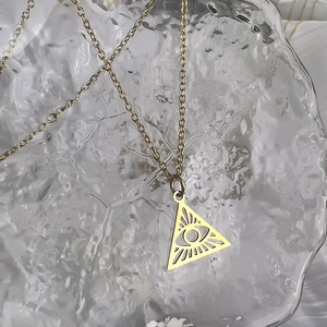 Detailed close-up of 18K gold-plated Evil Eye pendant with hollow triangle design