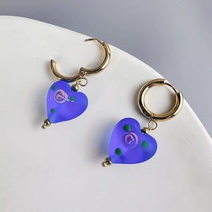 Detail of vintage matte purple heart-shaped glass earrings with gold stainless steel