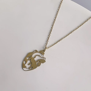 Vue macro d'un pendentif coeur anatomique au design ajouré sur collier doré