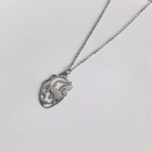 Détail du pendentif cœur argenté avec contour de visage artistique et chaîne fine élégante