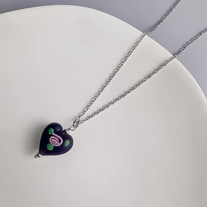 Vue détaillée du pendentif cœur violet rétro avec rose rose incrustée sur chaîne argentée