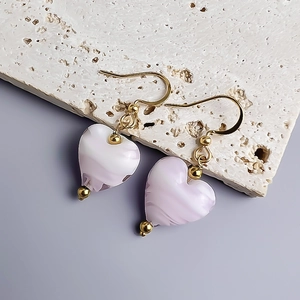 Close-up of lavender heart earrings with ink ripple texture and gold hooks
