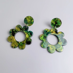 Dettaglio macro di orecchini a fiore in acrilico con trama marmorizzata verde stile pittura