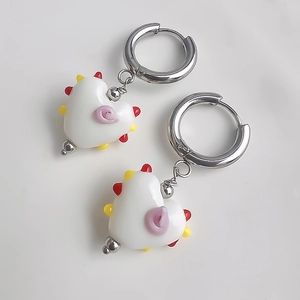 Détail des boucles d'oreilles en cœur avec perles colorées et spirale violette