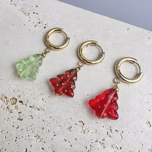 Boucles d'oreilles sapin de Noël en acier plaqué or 18K sur marbre blanc travertin