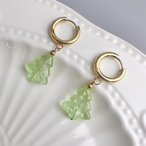 Détail de boucles d'oreilles sapin de Noël plaquées or 18K sur plateau céramique