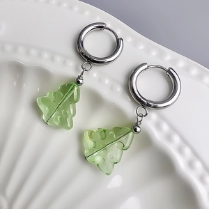 Vue macro de boucles d'oreilles feuilles vert clair sur une assiette en forme de coquillage