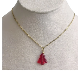 Golden necklace featuring a red glass Christmas tree pendant shown on a model bust