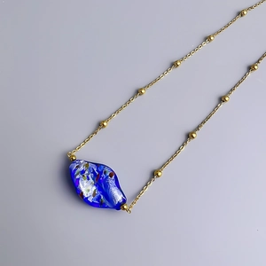 Handcrafted gold bead chain necklace featuring an artistic irregular blue glazed pendant
