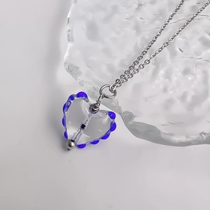 Macro d'un pendentif cœur en verre avec perles bleu cobalt sur une chaîne en acier argent