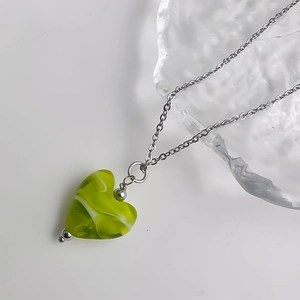 Détail du pendentif en cœur avec texture marbrée verte et blanche sur chaîne argentée