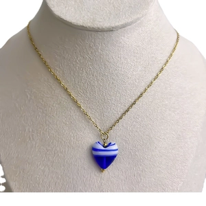 Pendentif cœur à rayures bleues et blanches sur chaîne dorée sur buste d'exposition