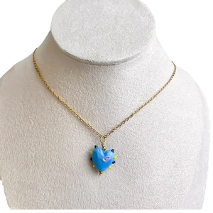 Ketting met blauwe glazen hartjes hanger en kleurrijke patronen aan gouden ketting