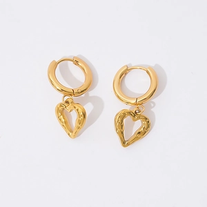Détail de boucles d'oreilles cœur dorées avec une texture martelée au style vintage chic
