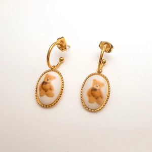 Vue détaillée de boucles d'oreilles vintage en or avec motif d'ours en peluche mignon