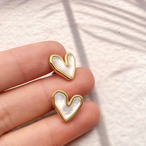 Titanium steel heart earrings with cat eye stone on a finger showing realistic size