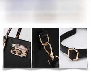 Close-up of black lychee grain leather tote with leopard print handle and gold hardware