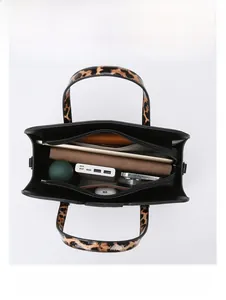 Top view of large black leather tote interior showing organized multi-layer storage capacity