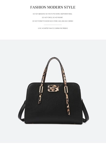 Detail view of black pebble leather tote featuring leopard print straps and gold hardware