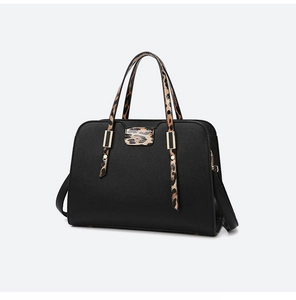 Close-up of black leather tote with leopard print handles and gold hardware details