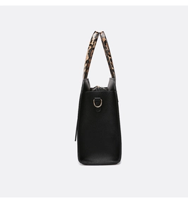 Detail of black pebbled leather tote bag with leopard print handle and gold D-ring