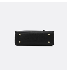 Detail view of the black lychee grain leather tote base with four gold metal feet