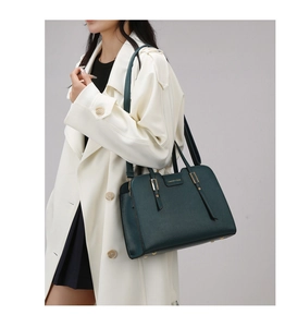 Detailed shot of dark green tote bag with lychee texture leather and gold metal buckle