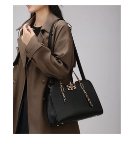 Detail of black pebbled leather handbag featuring stylish leopard print handles and accents
