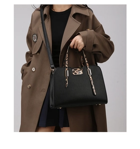 Detail of black pebbled leather handbag featuring leopard print handles and gold hardware