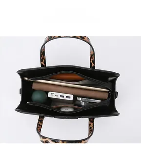 Top view of large black leather tote bag showing internal compartments and leopard straps