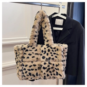 Detail of plush cow print handbag with quilted texture and soft faux fur material