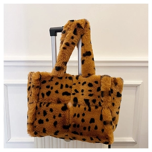 Detailed view of plush leopard print faux fur tote bag hanging on white luggage handle