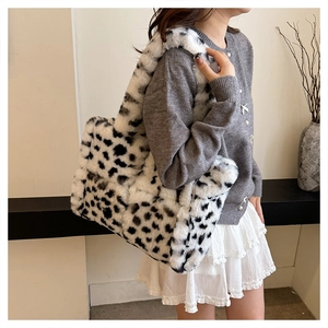 Detail of soft plush tote bag featuring black and white cow print and fuzzy texture