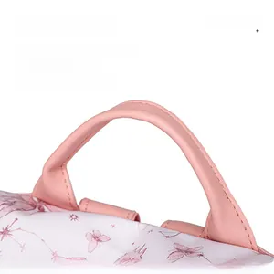 Detail of pink butterfly backpack handle featuring pebble leather and reinforced stitching