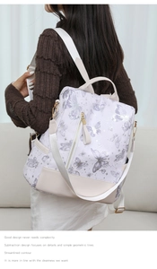 Detail of white butterfly print backpack with purple patterns and detachable strap