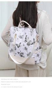 Detail of butterfly print backpack with gold zipper and durable beige fabric texture