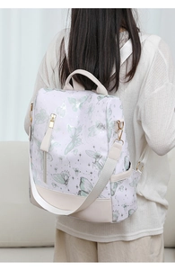 Detail view of the backpack's side pocket and adjustable shoulder straps on model