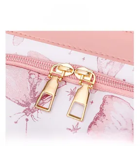 Detailed view of the smooth golden dual zipper on the pink butterfly print backpack