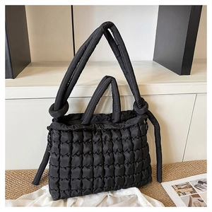 Détail d'un sac cabas en nylon matelassé noir avec texture bulles et poignée nouée