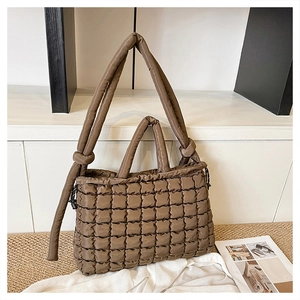 Détail d'un sac cabas marron matelassé avec texture bouffante et sangle à nœuds