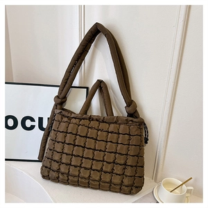 Détail du sac cabas en nylon matelassé marron foncé avec texture bulle et bandoulière nouée